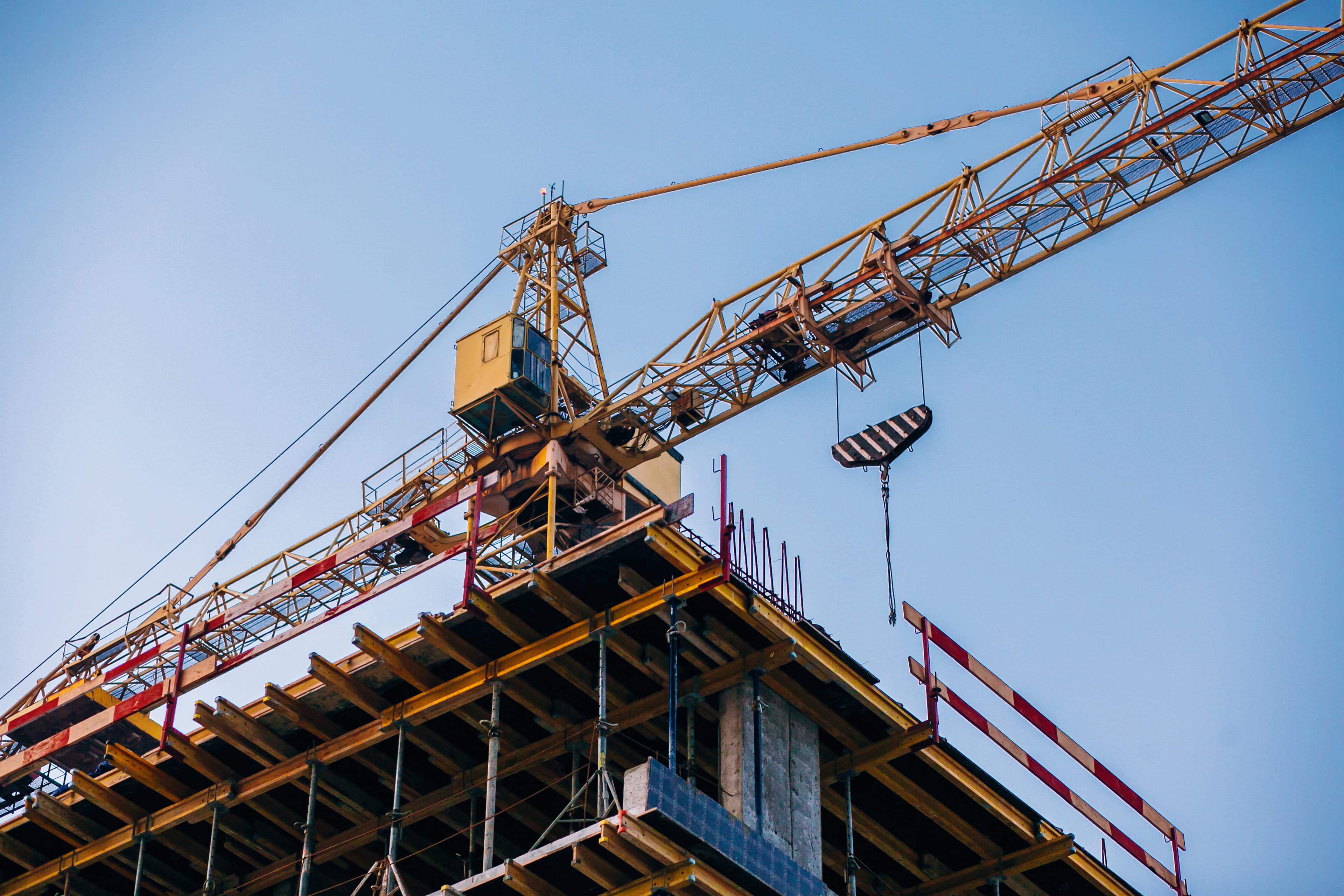 Grúa de construcción trabajando en la estructura de un edificio residencial de Lithos